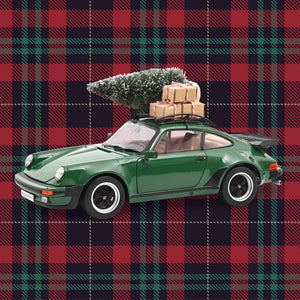 Norev Modellauto Porsche 911 Turbo 3.3 (1980) in Grün mit Weihnachtsbaum und Geschenken auf dem Dach, Maßstab 1:18, vor rot-grünem Schottenkaro-Hintergrund
